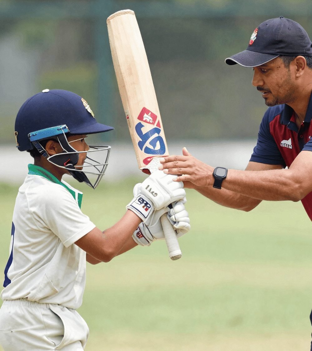 A young batter playing a shot during a match.