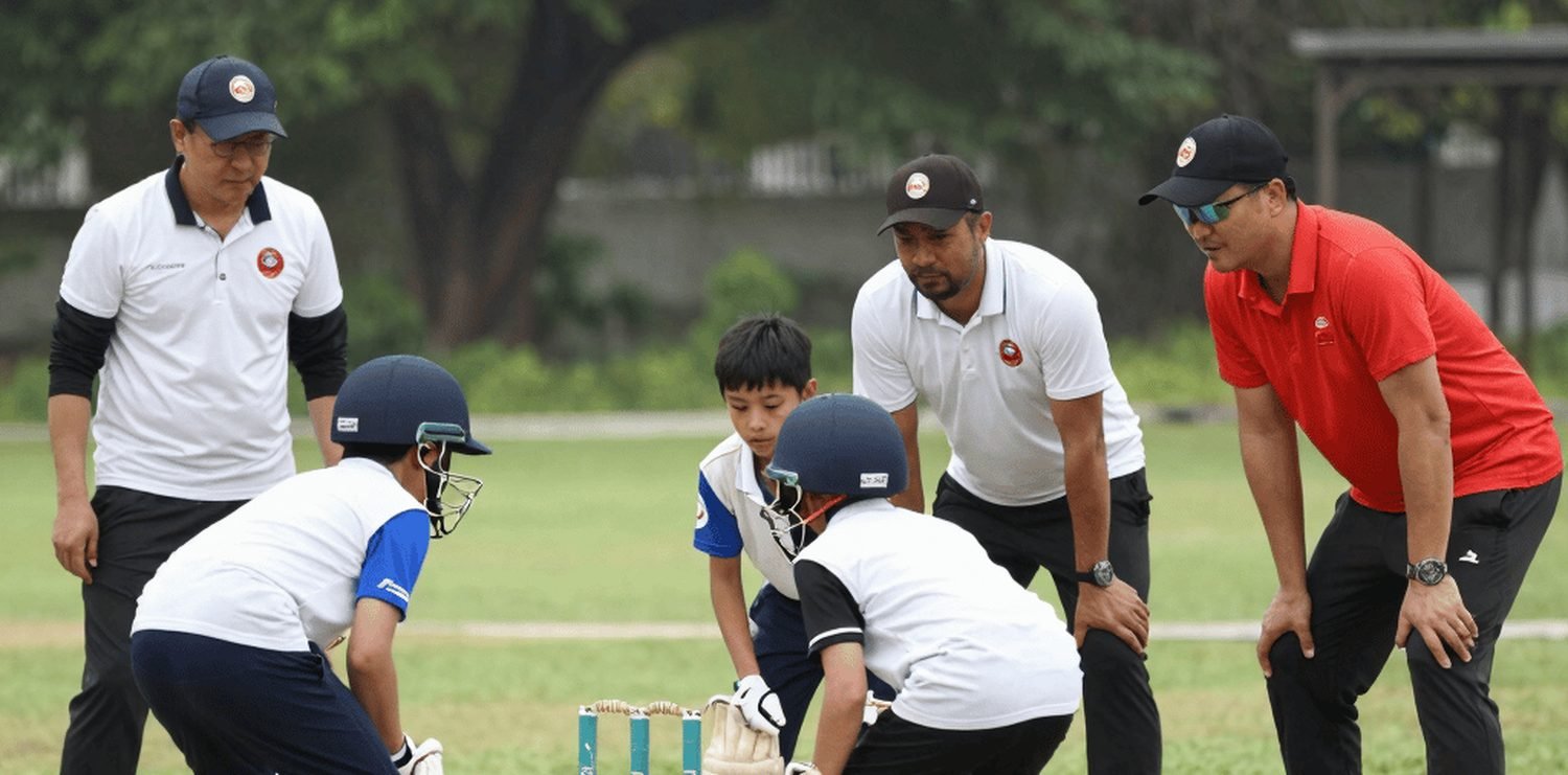 A group of young players and coaches on the field during a training session.